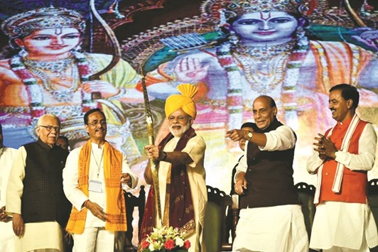 Prime Minister Narendra Modi holds a bow and arrow as he is welcomed on stage at the Aishbagh Ram Leela in Lucknow yesterday. Also seen are Uttar Pradesh Governor Ram Naik and federal Home Minister Rajnath Singh.