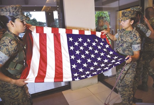 US marines and members of the colour guard prepare to fold their flag after the closing ceremony of the joint amphibious landing exercise with the Philippines at a military camp in Manila.