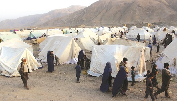Afghans displaced by ongoing fighting against Taliban militants walk inside a makeshift camp in Takhar province.  The number of war-displaced civilians in Kunduz has more than doubled to 24,000, the UN said, as street battles persisted a week after the Taliban stormed into the northern Afghan city.