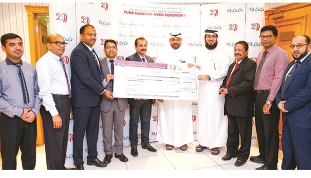 Dr Mohamed Salah Ibrahim of the RAF receiving the cheque for QR275,000 from Shaijan and Shanavas in the presence of RAF and LuLu Group officials.