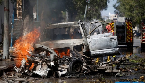 Firefighters try to extinguish flames from the wreckage of burning vehicles at the scene of an attack on a restaurant by the Somali Islamist group al Shabaab in the capital Mogadishu, Somalia.