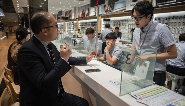 A customer inquires about returning a Samsung Note 7 mobile phone at a Samsung store in a mall beneath the company's headquarters in the Gangnam district of Seoul