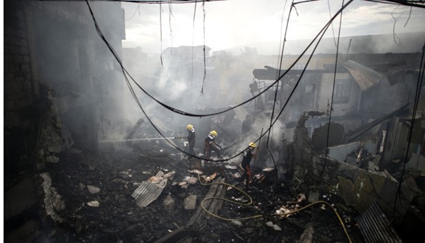 Firemen extinguish the fire at a fireworks shop in Bocaue, Bulacan, north of Manila