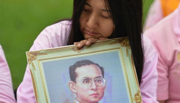 A Thai woman holds a portrait of King Bhumibol Adulyadej as she prays for his health at Siriraj Hospital in Bangkok on Wednesday.
