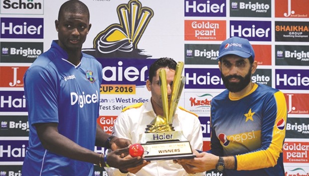 Pakistan captain Misbah-ul-Haq (right) and his West Indies counterpart Jason Holder hold the Test series trophy ahead of Asiau2019s day-night Test to be played in Dubai today. (AFP)