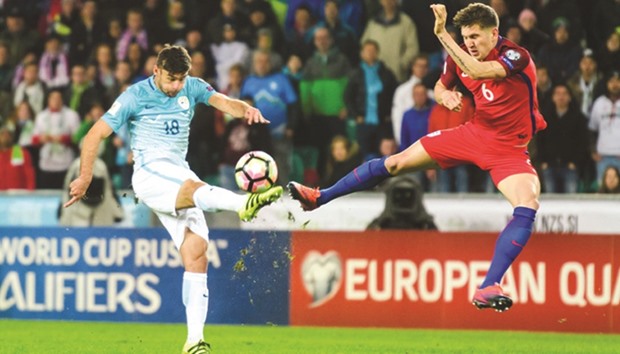 Sloveniau2019s Rok Kronaveter (L) vies for the ball with Englandu2019s John Stones during FIFA World Cup qualifying football match between Slovenia and England in Ljubljana.
