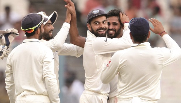 Indiau2019s Bhuvneshwar Kumar (right) celebrates with teammates after dismissing New Zealandu2019s Matt Henry during the second Test at The Eden Gardens cricket stadium in Kolkata yesterday. (AFP)