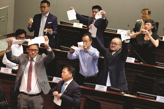 Pro-democracy lawmakers tear apart ballots as they boycott the process of electing the council chairman at the Legislative Council in Hong Kong yesterday.