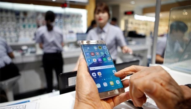 A customer uses his Samsung Galaxy Note 7 as he waits for an exchange at the company's headquarters in Seoul on Thursday.