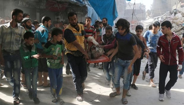 Syrians carry the body of a man following air strikes on the rebel-held Fardous neighbourhood in Aleppo on Wednesday.
