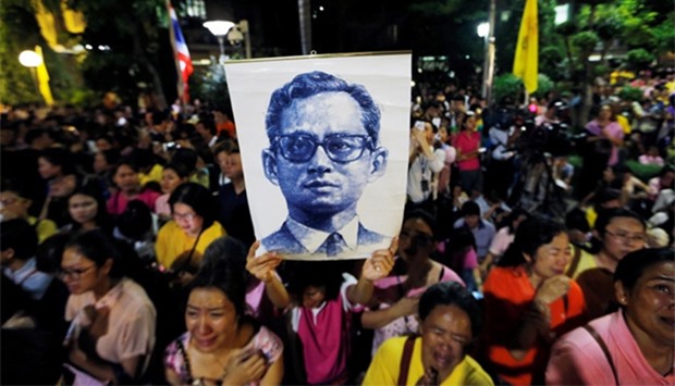 Well-wishers hold a picture of Thailand's King Bhumibol Adulyadej