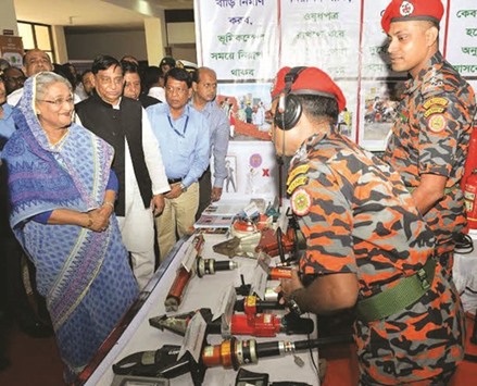 Prime Minister Sheikh Hasina meets fire service officials at a stall displaying equipment to deal with disasters in Dhaka yesterday.