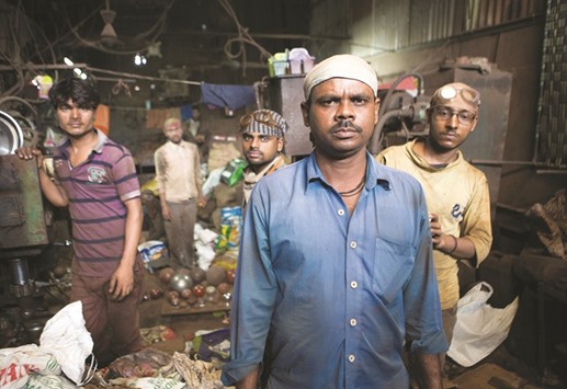 Recycling workers pose inside their workshop in Dharavi.