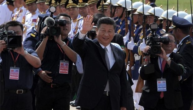 Chinese President Xi Jinping waves to Cambodian students and officials before departing from Phnom Penh international airport on Friday.