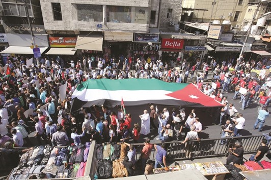 Jordanian protesters deploy a giant national flag during an Islamist-led opposition protest against a deal with Israel to import natural gas yesterday in the capital Amman.