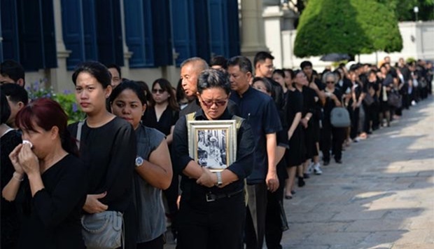 People wait in line to pay their respects to Thai King Bhumibol Adulyadej at the Grand Palace in Bangkok on Friday.