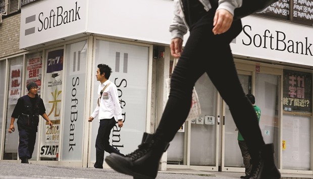 People walk past a retail shop of the SoftBank telecommunications company in Tokyo. The Japanese mobile carrier said it would invest about $25bn in the SoftBank Vision Fund over the next five years, while the Saudi Public Investment Fund will consider investing in the fund and becoming the lead investment partner.