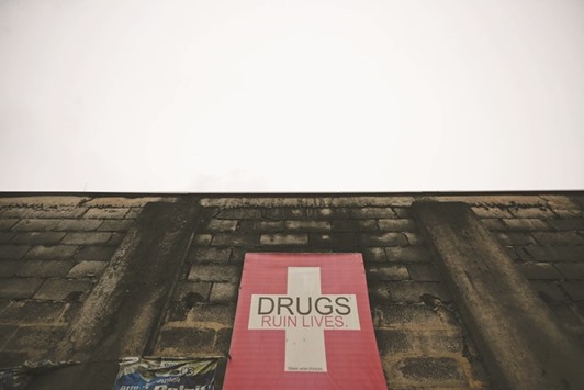 An anti-drug banner is displayed on a wall in Manila.