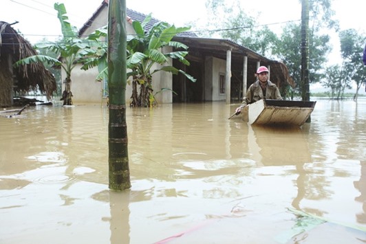 A man paddles a boat near his submerged house during a flood in Vietnamu2019s central Ha Tinh province yesterday.