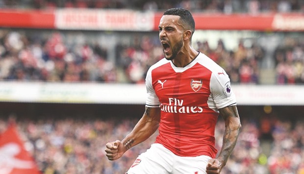 Arsenalu2019s English midfielder Theo Walcott celebrates after scoring their second goal against Swansea City yesterday.