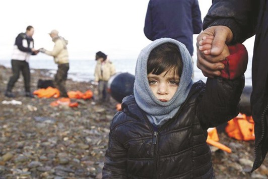 A Syrian refugee child looks on, moments after arriving on a raft with other  refugees on a beach on the Greek island of Lesbos earlier this year.