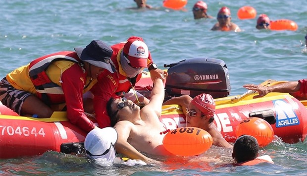 The swimmer, who later died in hospital, is pulled onto a boat during the annual harbour race