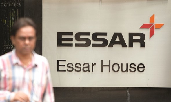 A pedestrian passes in front of the Essar Group corporate offices in Mumbai. The Indian conglomerate will sell 49% of Essar Oil each to Rosneft and the consortium for an enterprise value of $10.9bn.
