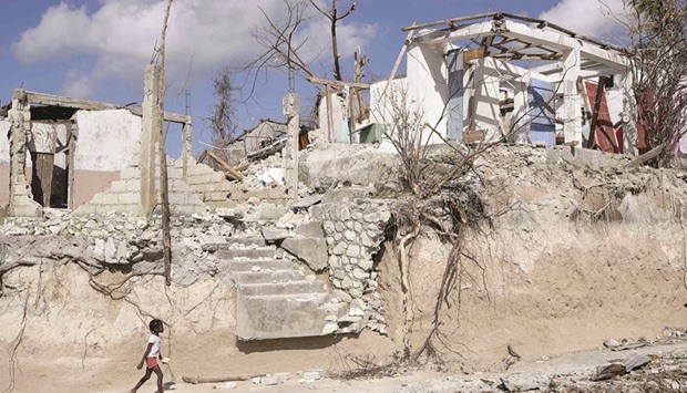 DESTRUCTION: A girl walks in Port Salut, Haiti, on October 12, following the passage of Hurricane Matthew. A week after Matthew tore through the country, many remote areasu2019 communities were still left to their own devices. Families with destroyed homes and shattered livelihoods waited and prayed for help.