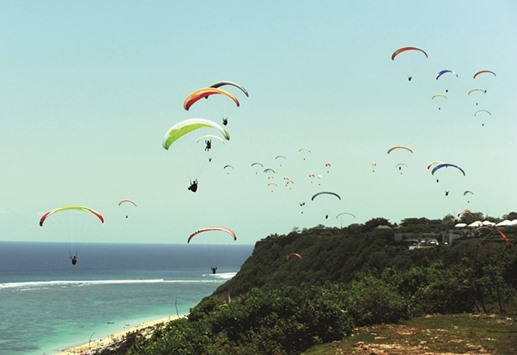 Paragliders sail through the sky during a record breaking attempt, involving more than 100 paragliders in Gunung Payung, Jimbaran on Indonesiau2019s resort island of Bali yesterday.