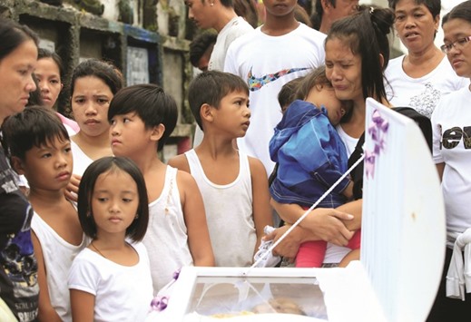 Loved ones and friends gather in front of the coffin to view the body of Apolinario Eyana Jr, who was killed by unidentified men, during his burial rites inside the public cemetery in Navotas city, Metro Manila, yesterday.