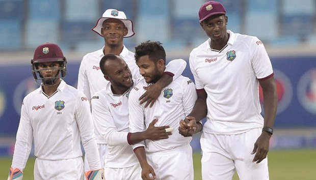 West Indies spinner Devendra Bishoo (second right) celebrates with teammates after taking the wicket of Pakistan batsman Asad Shafiq during the first Test in Dubai. (AFP)