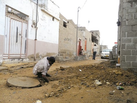 A labourer works to connect a house to new sewage line in Orangi Town, Karachi.