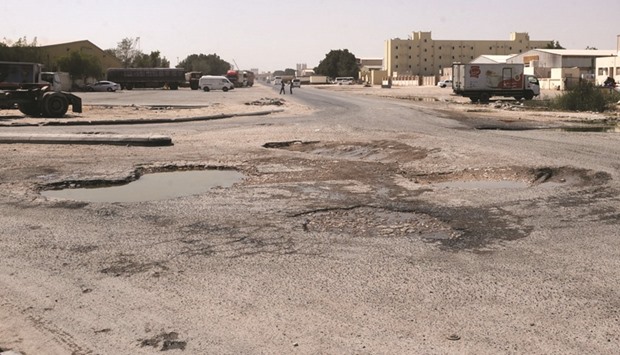 Several large potholes on a road in the Industrial Area.