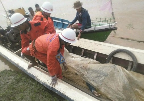 In this handout photograph released yesterday, government rescue personnel from the Myanmar Fire Services Department transport a victimu2019s body during a search operation after a ferry capsized on the Chindwin River near Monywa city in Sagaing region.