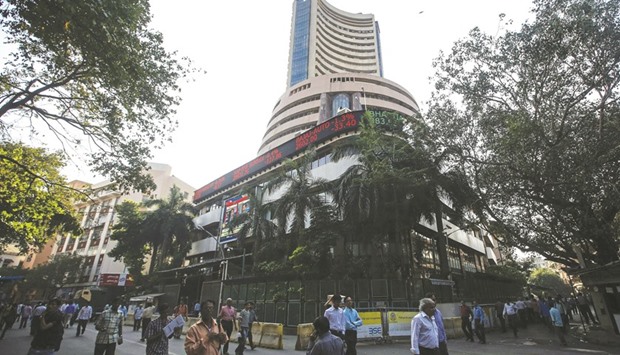 People walk by the Bombay Stock Exchange building in Mumbai. The Sensex closed down 143.63 points to 27,529.97 yesterday.