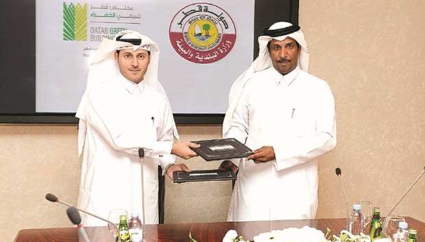 Meshal al-Shamari and Mansour Ajran al-Buainain exchanging papers after signing an MoU yesterday.
