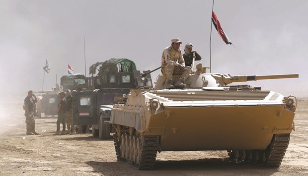 Iraqi forces hold a position yesterday in the area of Al-Shura, some 45km south of Mosul, as they advance towards the city to retake it from the Islamic State (IS) group militants. Some 30,000 federal forces are leading the offensive, backed by air and ground support from a 60-nation US-led coalition, in what is expected to be a long and difficult assault on ISu2019s last major Iraqi stronghold.