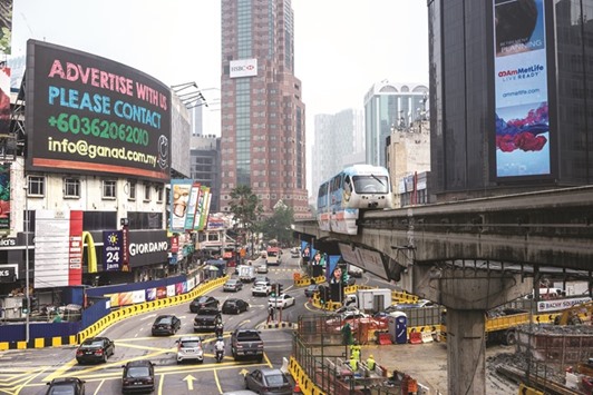 A monorail train travels along an elevated track as traffic passes a digital billboard in the Bukit Bintang area of Kuala Lumpur (file). Malaysia, which pioneered Islamic finance in the 1980s, is the worldu2019s biggest sukuk market.
