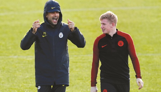 Manchester City manager Pep Guardiola (left) with midfielder Kevin De Bruyne during a training session on the eve of their Champions League match against Barcelona. (AFP)