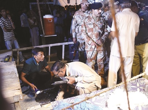 Pakistani investigators collect evidence after an attack on Imambargah (Shia mosque) in Karachi on Monday night.