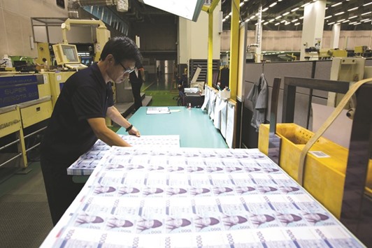 An employee inspects sheets of won banknote at the Korea Minting, Security Printing & ID Card Operating Corp factory in Geyongsan, South Korea. The currency, down 1.9% this month to 1,123.07 per dollar in Seoul yesterday, will drop to 1,143 by year-end, according to the median forecast in Bloomberg survey.