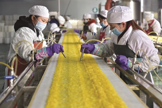 Employees work at a food processing factory in Yichang, Hubei province. Some economists believe China has had to u2018double downu2019 on stimulus this year to meet its official growth range of 6.5% to 7%, and say the governmentu2019s obsession with meeting hard targets may hurt both planned reforms and the long-term health of the worldu2019s second-largest economy.
