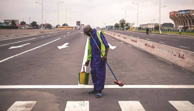 A public cleaner works on a deserted avenue as the Congolese capital Kinshasa was gripped by a strike called u2018Villes mortesu2019 (Dead cities) in a protest over plans by President Kabila to stay in power beyond the end of his term in December.