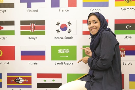 A course participant stands next to a flag wall in Dubai.