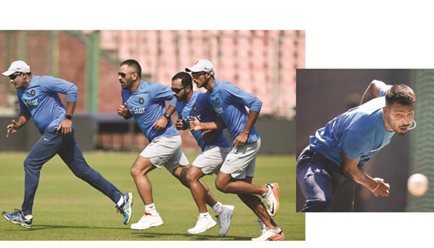 India cricket coach Anil Kumble (left) and captain Mahendra Singh Dhoni (second left) warm up with teammates during a training session at the Ferozshah Kotla stadium in New Delhi yesterday, on the eve of the second One Day International match against New Zealand.   (Right photo) Indian all-rounder Hardik Pandya bowls in the nets at the Ferozshah Kotla stadium in New Delhi yesterday. (AFP)