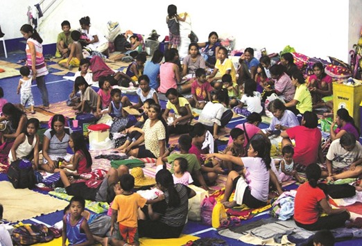 Evacuees from the coastal villages take shelter inside an evacuation centre as Typhoon Haima locally named Lawin approaches, in Alcala town, Cagayan province, north of Manila yesterday.