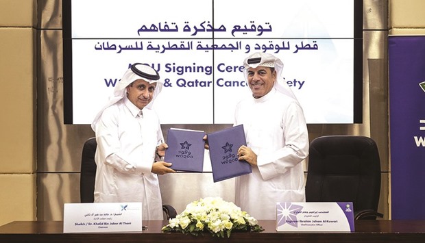 Sheikh Dr Khalid bin Jabor al-Thani and Ibrahim Jaham al-Kuwari exchange the agreement.
