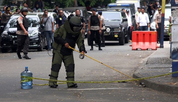 A bomb squad policeman inspect a bomb suspected object at location