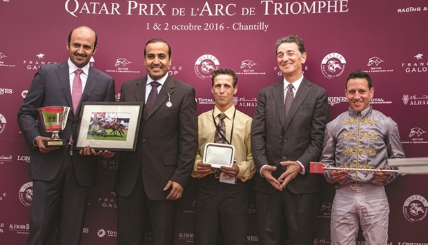 QREC board chairman Eissa al-Mohannadi poses with the connections of Doha Dream. At bottom, QREC GM Nasser bin Sharida al-Kaabi poses after giving the trophy to winning jockey George Baker who rode Quest For More to victory  in the Qatar Prix Du Cadran, a Group 1 race run over 4,100 metres.