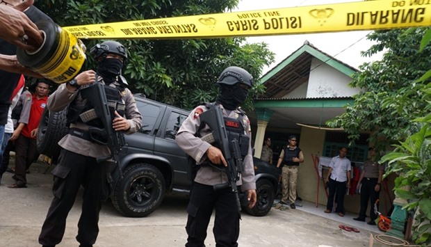 Anti-terror police secure the residence of a suspect, who attacked several policemen on duty at an intersection, in Tangerang, Banten province, Indonesia. Police shot dead the man, who was carrying knives, suspected pipe bombs and a symbol of the Islamic State group
